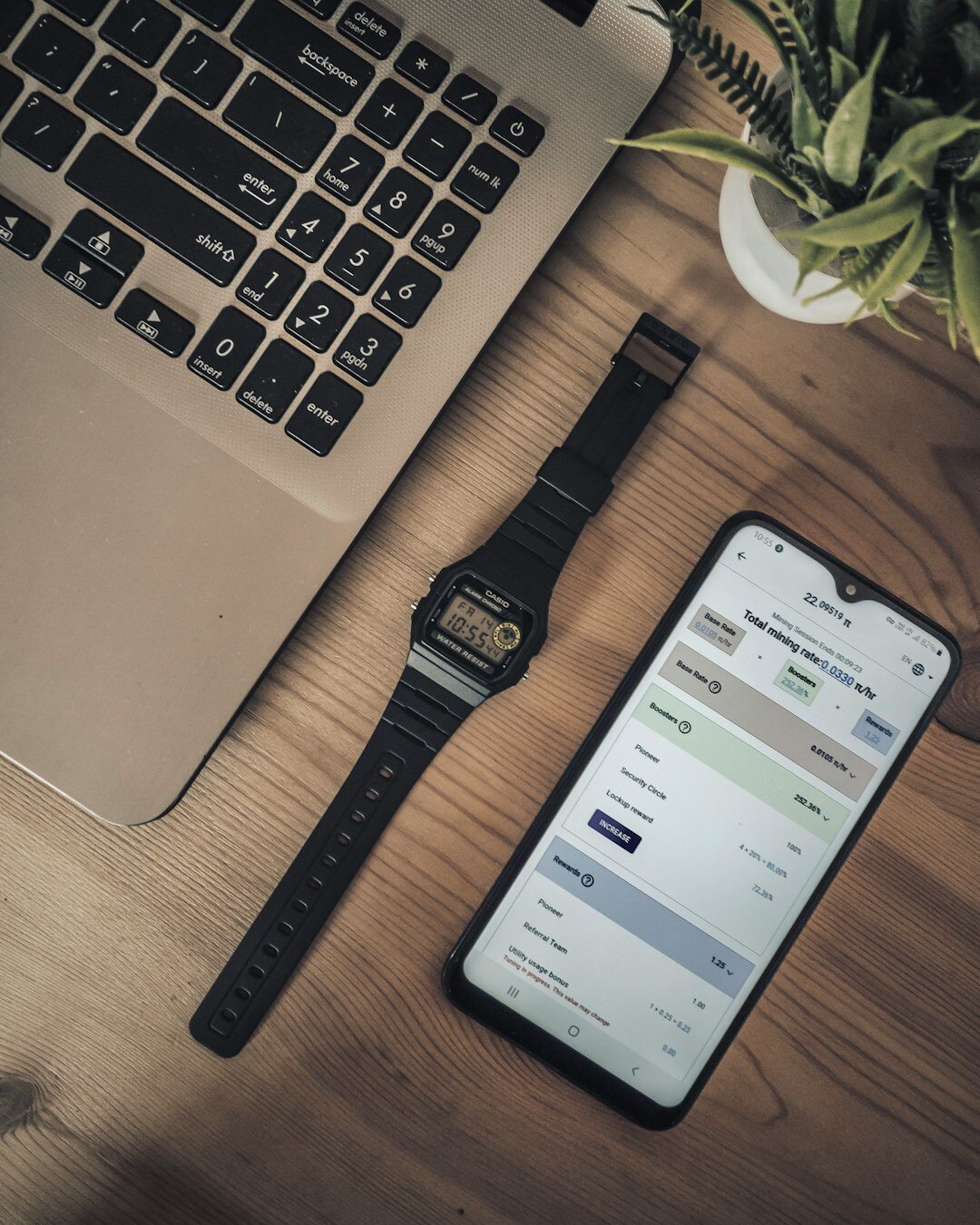 Close up of a fitness tracking app on a smartphone next to a laptop